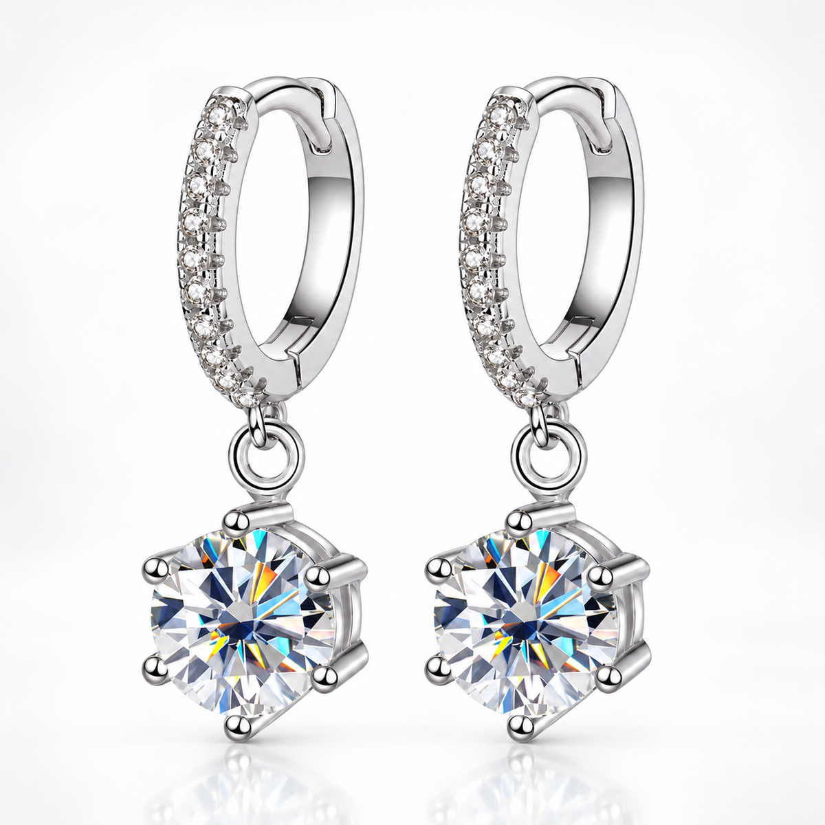 Silver pavé hoop drop earrings with round moissanite solitaires on a white background