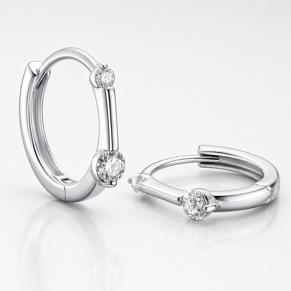 Silver floating moissanite hoop earrings with two round colourless stones shown on a white background