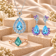Natural gemstone jewellery featuring blue and purple drop earrings, a blue gemstone pendant necklace and a green gemstone ring.