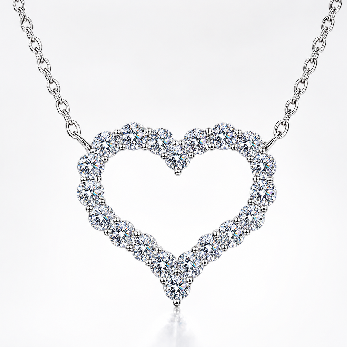 Silver open heart moissanite necklace with round stones set around the heart-shaped pendant on a white background.