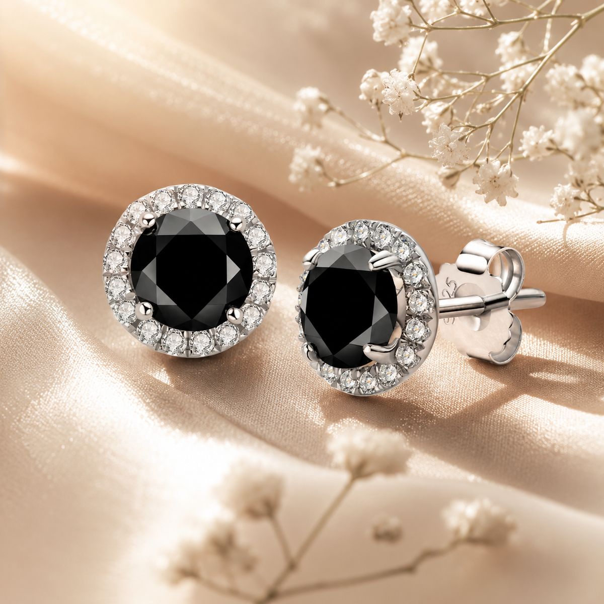 Silver black moissanite halo stud earrings displayed on champagne satin with flowers