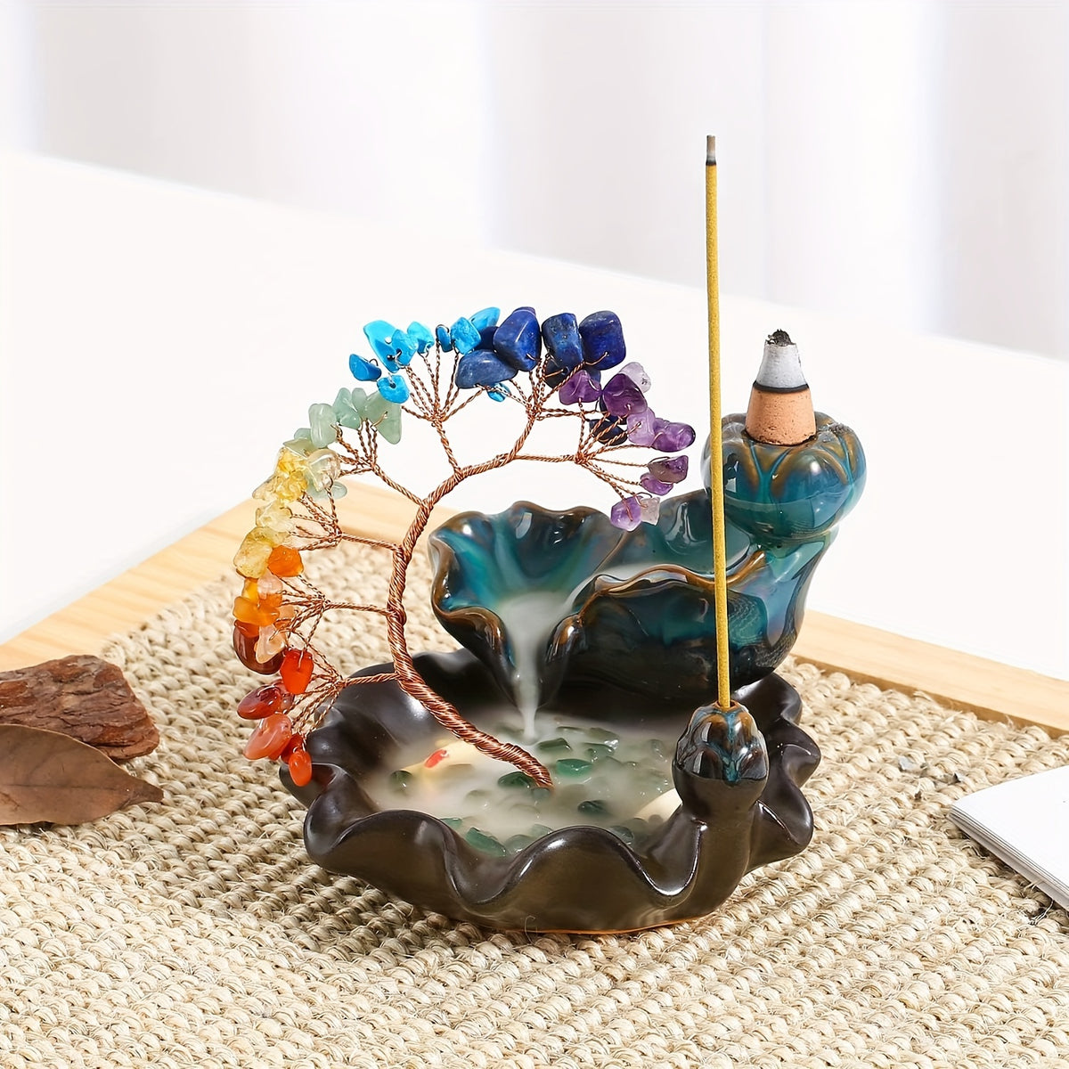Holistic chakra incense burner with colourful crystal tree and agate base on woven mat, perfect for yoga and relaxation spaces