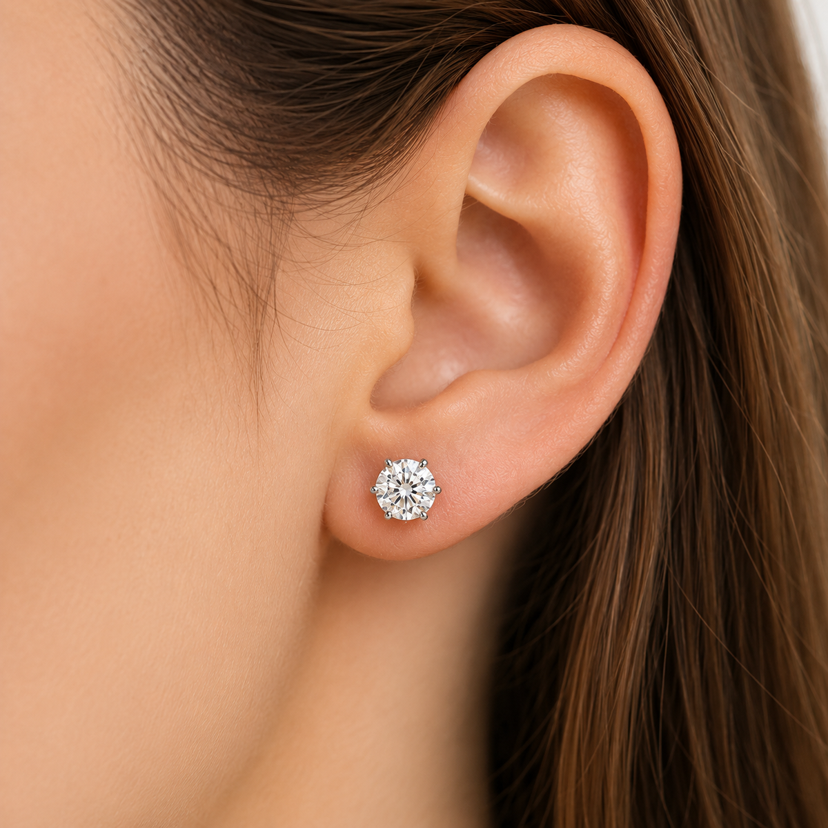 White gold six-prong colourless moissanite stud earrings shown front and side on a white background