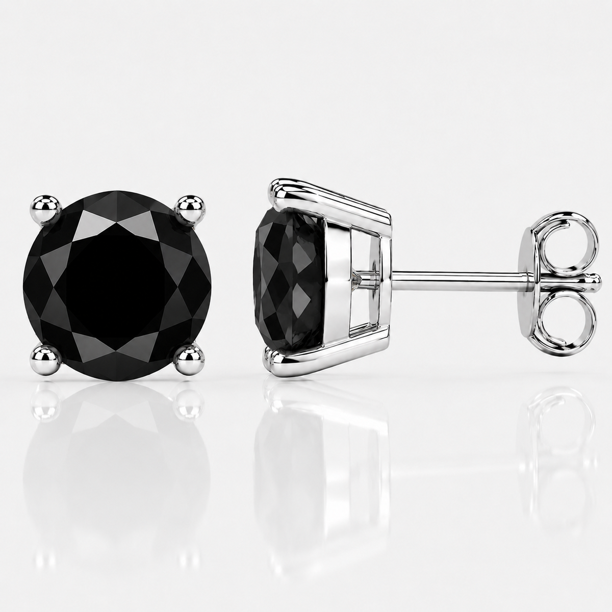 Silver four-prong black moissanite stud earrings shown front and side on a white background