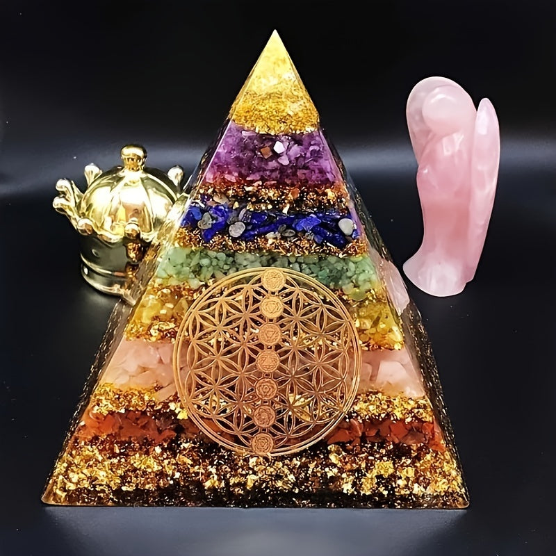 Close-up of a 7 chakra orgone pyramid with Flower of Life and crystals, surrounded by a rose quartz angel and gold crown on a black background