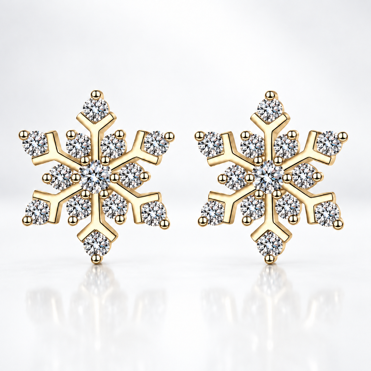Gold snowflake moissanite stud earrings on a white background