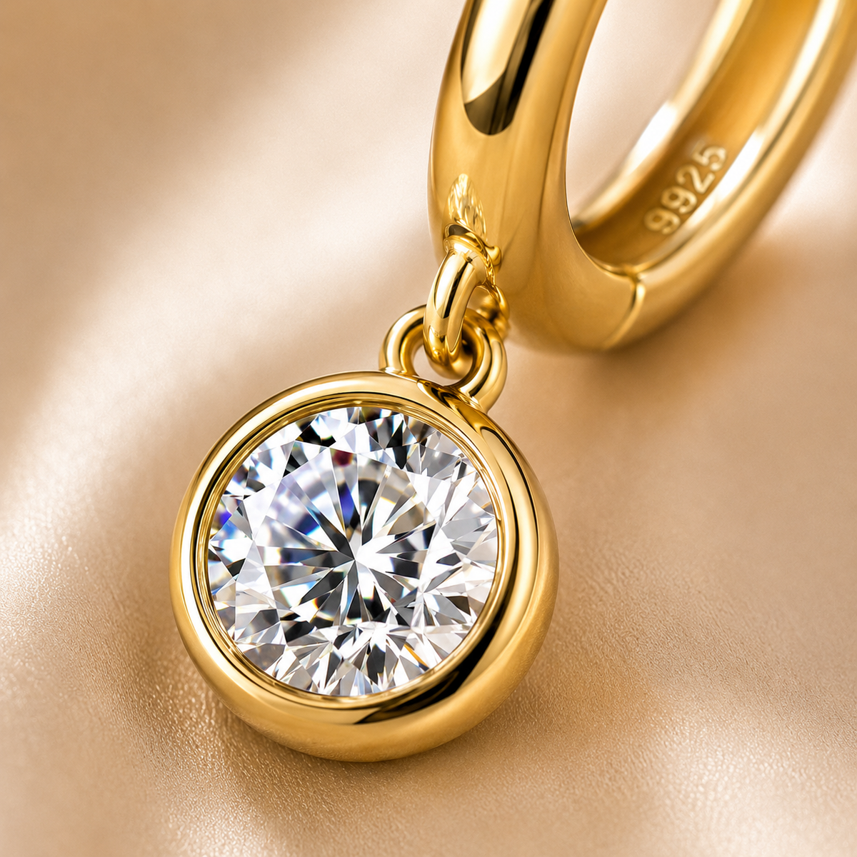 Macro close-up of a gold bezel-set round moissanite drop and hoop earring