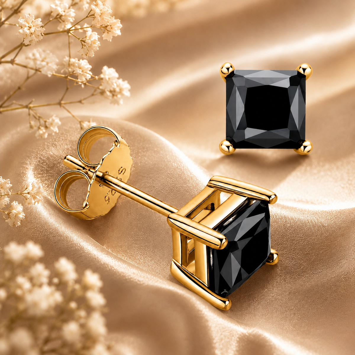 Gold princess cut black moissanite stud earrings displayed on champagne satin