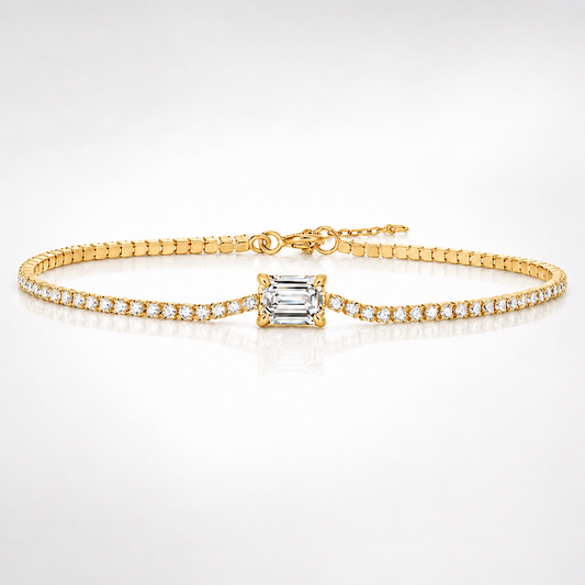 Yellow gold-tone moissanite tennis bracelet with emerald-cut centre stone and round stone accents on white