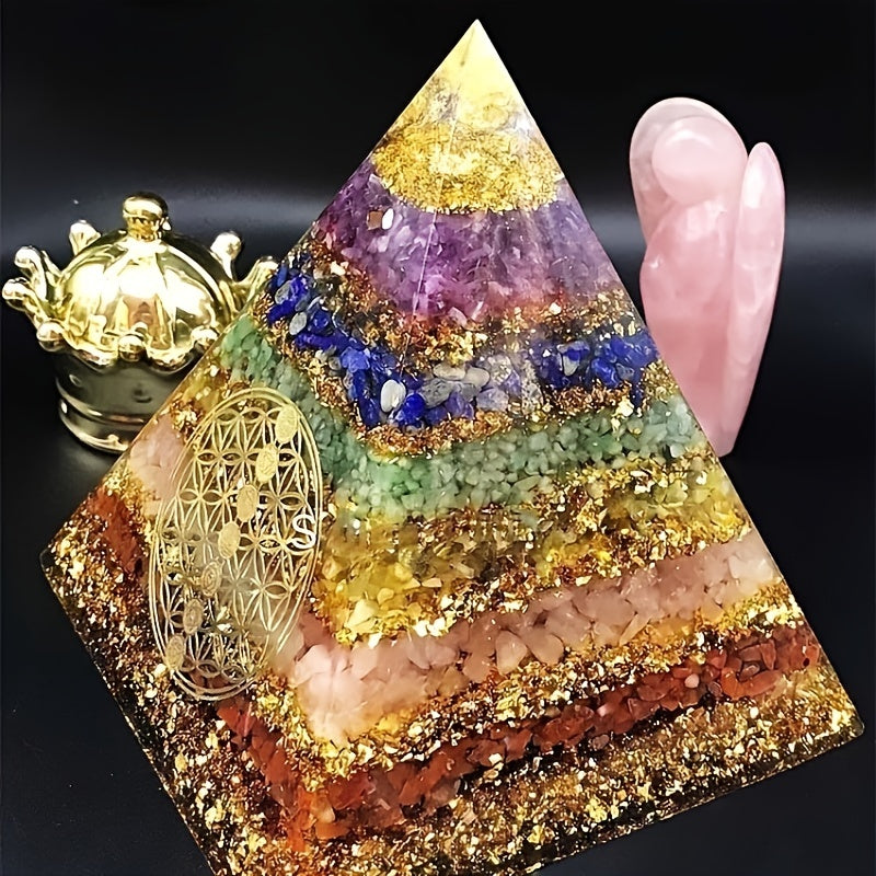 Angled side view of a large chakra orgone pyramid featuring gemstone layers and Flower of Life, positioned next to holistic décor.