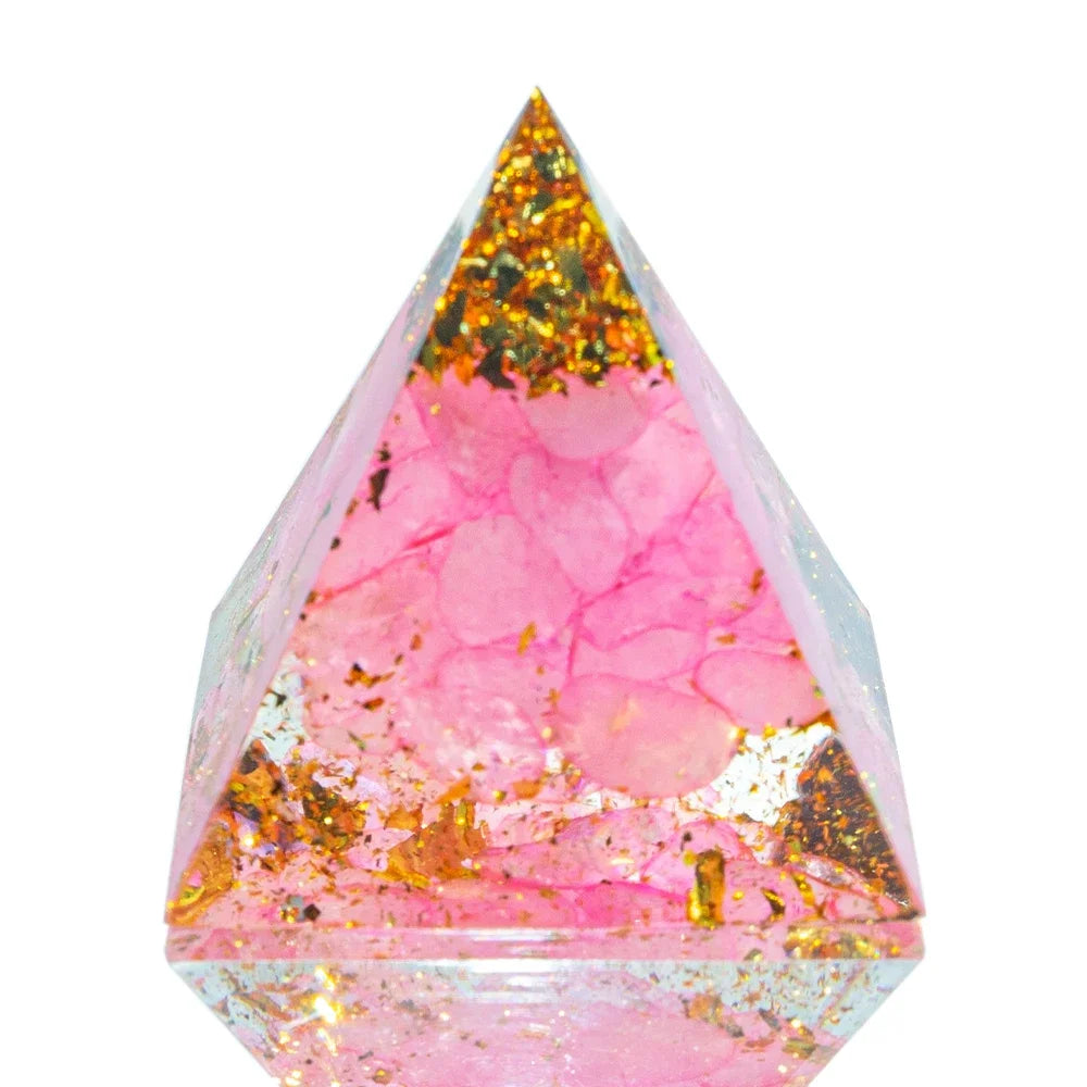 A 3cm orgone pyramid featuring soft pink healing crystals and gold foil flakes encased in clear resin, crafted to promote love, emotional healing, and heart chakra balance.