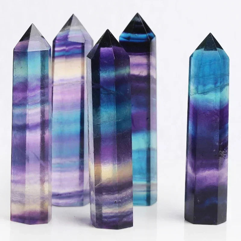 Five vibrant fluorite crystal towers featuring natural banded layers in purple, blue, green, and clear hues. Known for mental clarity, focus, and spiritual protection.