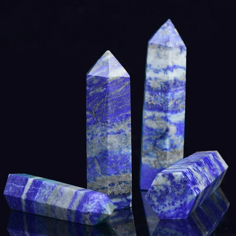 Four lapis lazuli crystal towers in vivid blue tones with white and gold marbling, arranged on a glossy black surface. Known for truth, wisdom, and third eye activation.