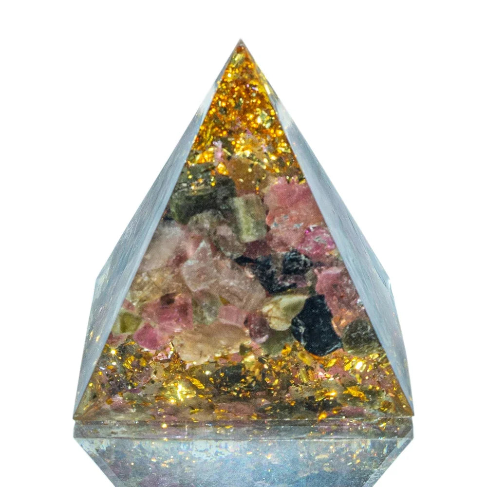 A 3cm orgone pyramid featuring natural pink, green, and black tourmaline crystals encased in clear resin with sparkling gold foil, designed for emotional healing, energy balancing, and EMF protection.