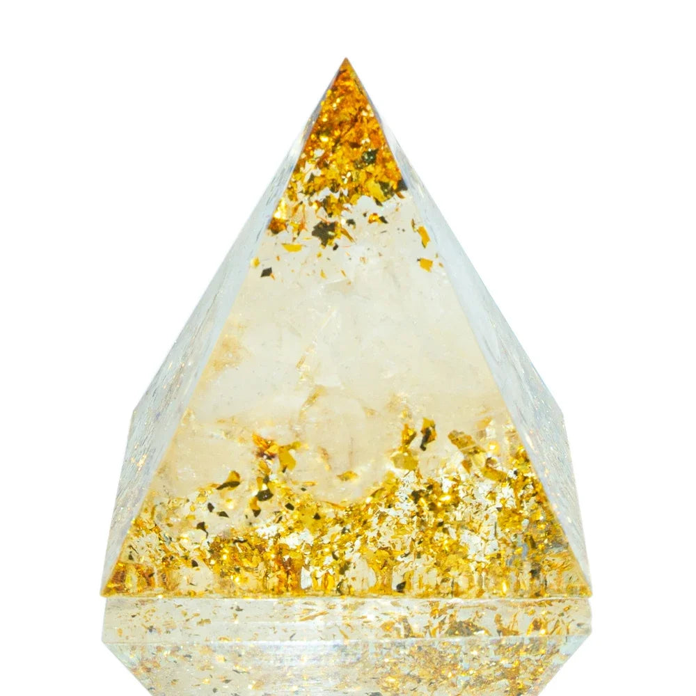 A 3cm orgone pyramid featuring clear and white healing crystals, accented with shimmering gold foil flakes and encased in transparent resin. Created to enhance purity, clarity, and spiritual alignment.
