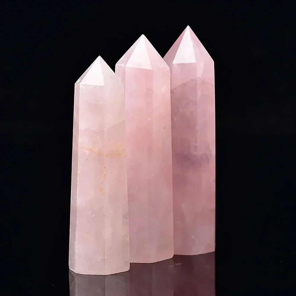 Three rose quartz crystal towers in soft pink tones, displayed upright against a black background. Symbolic of love, compassion, and emotional healing.