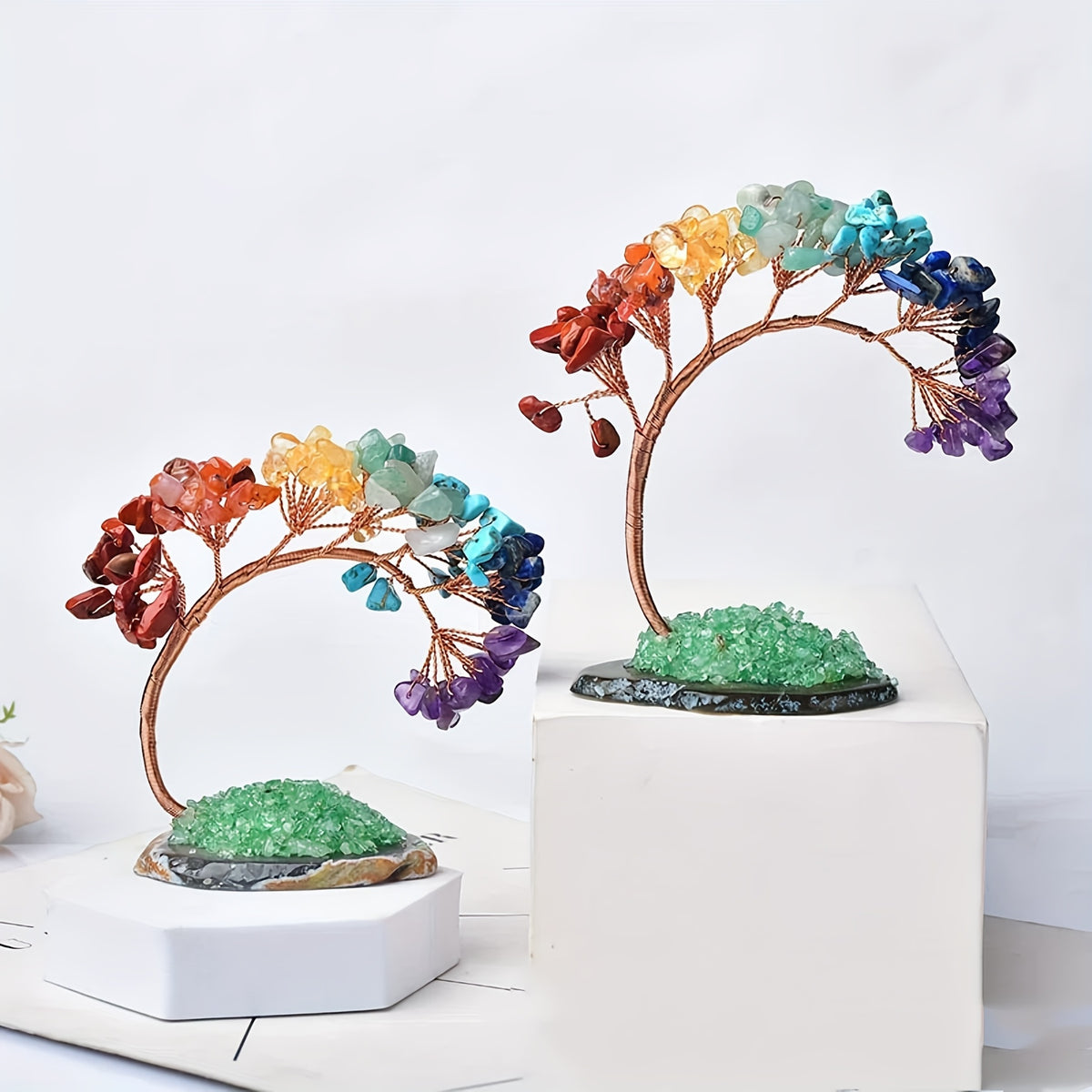 Two rainbow gemstone bonsai trees on display cubes, featuring green druzy bases and vibrant crystal leaves.