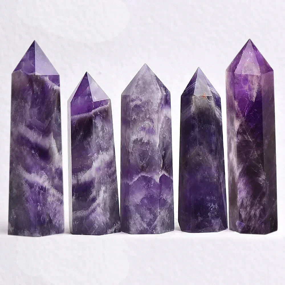 Five natural amethyst crystal towers in various shades of purple with marbled patterns, arranged upright against a light background. Popular for spiritual protection and calming energy.