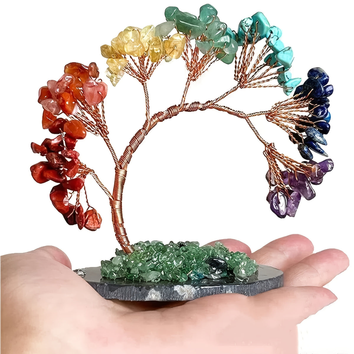 Crystal healing tree sculpture with arched trunk and rainbow gemstone leaves held in palm, showing moderate size and fine detail.